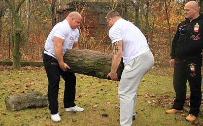 Members of the Polish Strongman Federation, headed by former world champion Tomasz Kowal (left) remove a Jewish gravestone from an urban farm plot in Warsaw. (courtesy From the Depths)