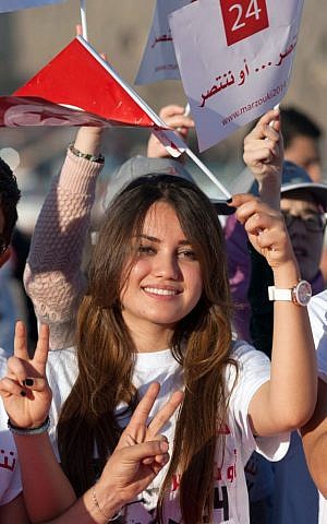 A supporter of presidential candidate and Tunisian President, Moncef Marzouki, waves her national flag during a campaign meeting in Bizerte, northern Tunisia, Wednesday, Nov. 19, 2014 (photo credit: AP/Aimen Zine)