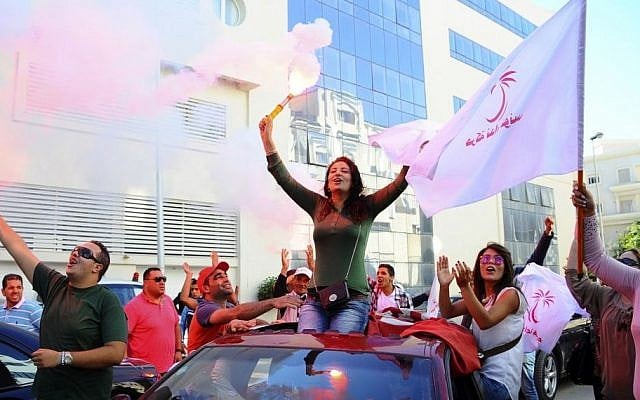 Supporters of Tunisian party Nida Tunis (Tunisia Calls) celebrate their victory in parliamentary elections in Tunis, October 28, 2014. (photo credit: AP/Hassene Dridi) Supporters of Tunisian party Nida Tunis (Tunisia Calls) celebrate their victory in parliamentary elections in Tunis, October 28, 2014. (photo credit: AP/Hassene Dridi)