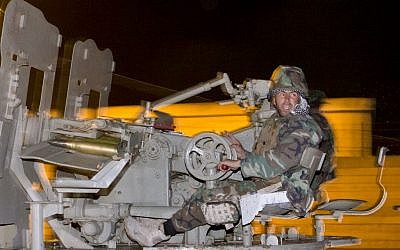 An Iraqi Kurdish peshmerga fighter rides on an artillery weapon as he leaves the outskirts of Suruc, Turkey, towards the Turkey-Syria border, on the way to the Syrian city of Kobani, Friday, Oct. 31, 2014. (photo credit: AP/Vadim Ghirda)