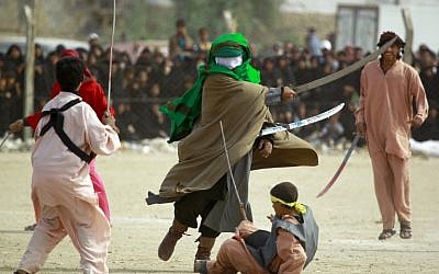 Iraqi Shiite men perform during the reenactment of the Battle of Karbala as part of the Ashura commemorations, that mark the killing of Imam Hussein -one of Shiite Islam's most revered figures- in the Shiite holy city of Najaf, central Iraq, on November 4, 2014. (photo credit: AFP PHOTO/HAIDAR HAMDA) Iraqi Shiite men perform during the reenactment of the Battle of Karbala as part of the Ashura commemorations, that mark the killing of Imam Hussein -one of Shiite Islam's most revered figures- in the Shiite holy city of Najaf, central Iraq, on November 4, 2014. (photo credit: AFP PHOTO/HAIDAR HAMDA)