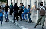 A masked Palestinian throws a firebomb at Israeli forces at the main entrance of the West Bank town of Bethlehem on November 11, 2014 (photo credit: AFP/ Musa Al Shaer)