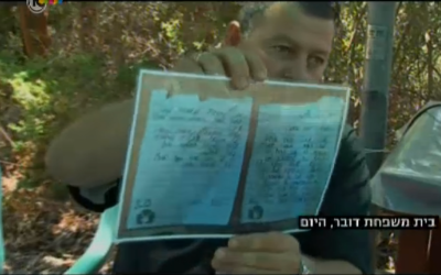 Boris Dauber, the father of fallen IDF soldier First Sgt. Shahar Dauber, with a laminated copy of his son's farewell letter (screen capture: Channel 10 news)