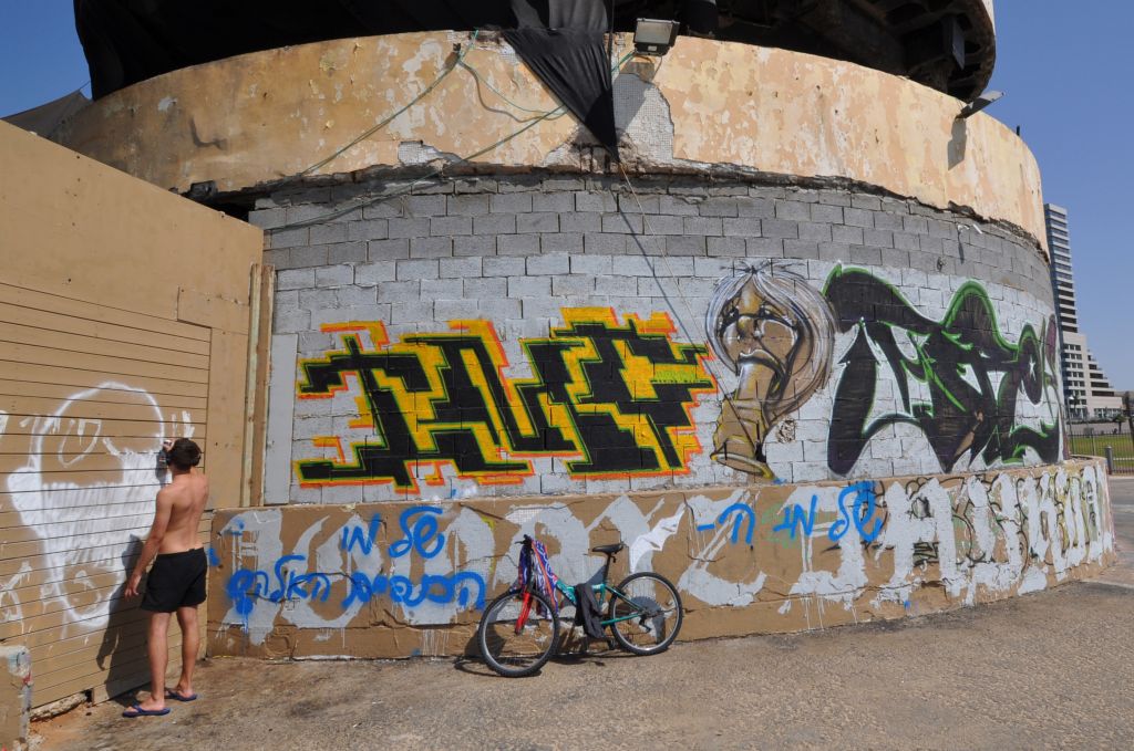 A man sprays graffiti on the sea-facing side of the abandoned Dolphinarium building in Tel Aviv in 2013. (Photo credit: Hannah Morrow/Flash90) A man sprays graffiti on the sea-facing side of the abandoned Dolphinarium building in Tel Aviv in 2013. (Photo credit: Hannah Morrow/Flash90)