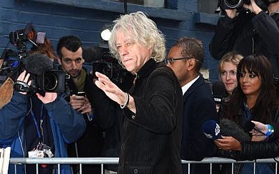 Singer Bob Geldof waves to fans as he arrives at a music studio to record his segment of the new Band Aid 30 charity single in London, Saturday, Nov. 15 2014. (Photo credit: Jonathan Short/Invision/AP)