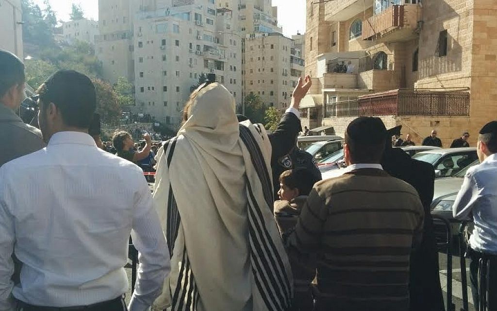 Bystanders in Jerusalem's Har Nof neighborhood at the scene of a terror attack in a synagogue that left at least four dead (photo credit: Times of Israel/Marissa Newman)