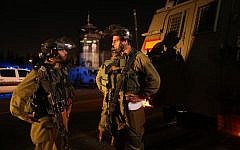 Israeli soldiers seen at the entrance to the Palestinian village of Al Aroub, West Bank, where three Israeli soldiers were injured Wednesday in a hit-and-run near the Gush Etzion junction, November 05, 2014. (photo credit: Nati Shohat/Flash90)