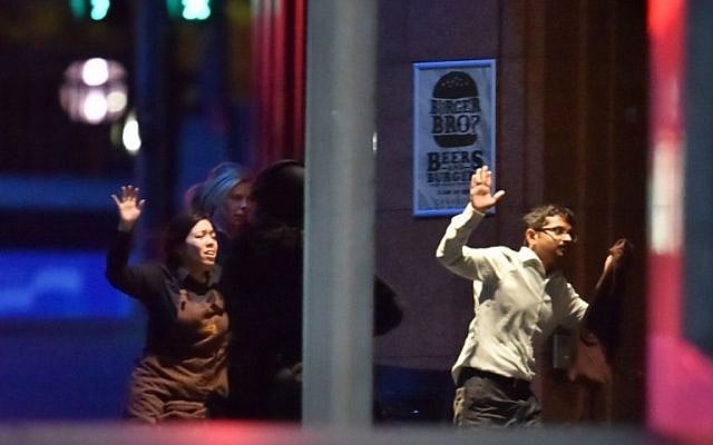 Hostages run out of a cafe in the central business district of Sydney on December 16, 2014 (photo credit: AFP/Peter PARKS) Hostages run out of a cafe in the central business district of Sydney on December 16, 2014 (photo credit: AFP/Peter PARKS)