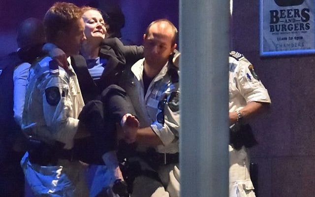 An injured hostage is carried out of a cafe in the central business district of Sydney on December 16, 2014. Police stormed the Sydney cafe where a gunman had taken hostages and displayed an Islamic flag, television footage showed early December 16 (photo credit: AFP/Peter PARKS) An injured hostage is carried out of a cafe in the central business district of Sydney on December 16, 2014. Police stormed the Sydney cafe where a gunman had taken hostages and displayed an Islamic flag, television footage showed early December 16 (photo credit: AFP/Peter PARKS)