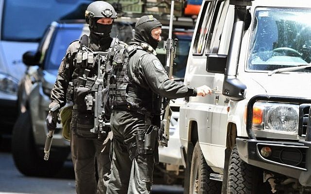 A police sniper team walk to their vehicle during a hostage siege in the central business district of Sydney on December 15, 2014. (Photo credit: AFP/William WEST) A police sniper team walk to their vehicle during a hostage siege in the central business district of Sydney on December 15, 2014. (Photo credit: AFP/William WEST)