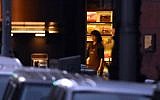 A female hostage stands by the front entrance of the Lindt cafe as she turns the lights off, December 15, 2014. AFP PHOTO/William WEST