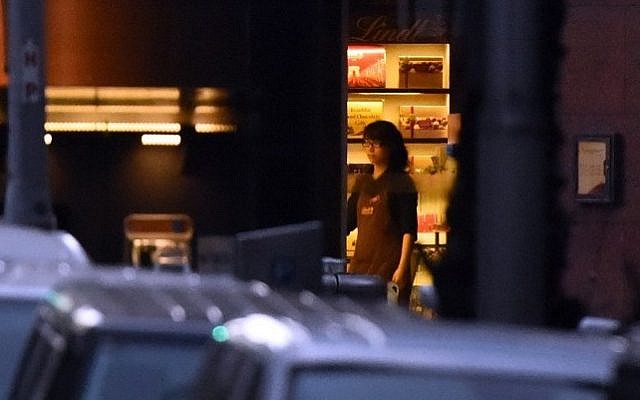 A female hostage stands by the front entrance of the Lindt cafe as she turns the lights off, December 15, 2014. AFP PHOTO/William WEST A female hostage stands by the front entrance of the Lindt cafe as she turns the lights off, December 15, 2014. AFP PHOTO/William WEST