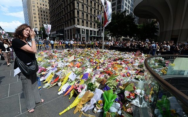 A visitor looks at a makeshift memorial near the scene of a fatal siege in the heart of Sydney's financial district on December 16, 2014. (photo credit: AFP/Peter Parks)