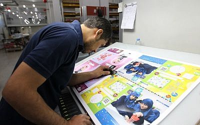 An employee checks the printing of the Mahdi magazine, produced by the Shiite Hezbollah movement, on November 24, 2014 in the Lebanon capital Beirut. (photo credit: AFP/ANWAR AMRO)
