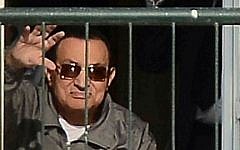 Egypt's former president Hosni Mubarak waves to his supporters from the balcony of his room at the Maadi military hospital in Cairo on November 29, 2014. (AFP/Al-Watan newspaper/Mohamed Nabil)