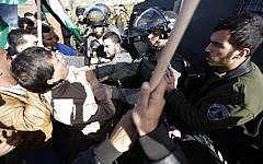 A border policeman grabs Palestinian official Ziad Abu Ein (L) during a demonstration in the West Bank on Wednesday, December 10, 2014 (photo credit: AFP/ABBAS MOMANI)