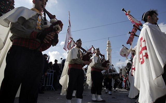 Palestinian Christian scouts perform at Manger Square outside the Church of the Nativity as Christians gather for Christmas celebrations in the West Bank city of Bethlehem, on December 24, 2014. (photo credit: AFP PHOTO/AHMAD GHARABLI)