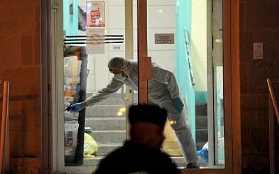 Forensic police collect evidence outside the police station of Joue les-Tours on December 20, 2014 where French police shot dead a man who attacked them with a knife. (photo credit: AFP/GUILLAUME SOUVANT)