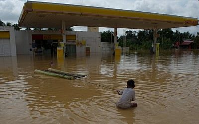 A boy plays in floodwaters near a petrol station in Pengkalan Chepa, near Kota Bharu on December 26, 2014. (Photo credit: AFP) A boy plays in floodwaters near a petrol station in Pengkalan Chepa, near Kota Bharu on December 26, 2014. (Photo credit: AFP)