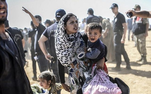 A Syrian Kurdish woman crosses the border between Syria and Turkey at the southeastern town of Suruc in Sanliurfa province on September 23, 2014. (photo credit: AFP/BULENT KILIC) A Syrian Kurdish woman crosses the border between Syria and Turkey at the southeastern town of Suruc in Sanliurfa province on September 23, 2014. (photo credit: AFP/BULENT KILIC)