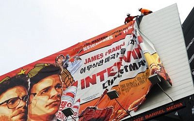 Workers remove the poster for "The Interview" from a billboard in Hollywood, California, December 18, 2014 a day after Sony announced it had no choice but to cancel the movie's Christmas release and pull it from theaters due to a credible threat. (Photo credit: AFP/ VERONIQUE DUPON)