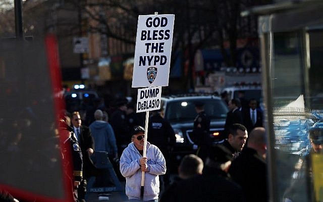 An anti-Mayor Bill de Blasio protester holds up a sign outside of Christ Tabernacle Church for the funeral of slain New York City Police Officer Rafael Ramos, one of two officers murdered while sitting in their patrol car in an ambush in Brooklyn last Saturday afternoon, on December 27, 2014 in New York City (photo credit: Spencer Platt/Getty Images/AFP) An anti-Mayor Bill de Blasio protester holds up a sign outside of Christ Tabernacle Church for the funeral of slain New York City Police Officer Rafael Ramos, one of two officers murdered while sitting in their patrol car in an ambush in Brooklyn last Saturday afternoon, on December 27, 2014 in New York City (photo credit: Spencer Platt/Getty Images/AFP)