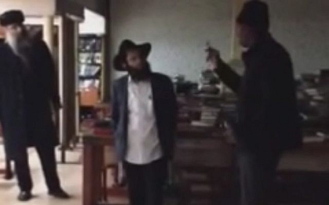 The suspected assailant, right, exchanging words with a Jewish man inside the Chabad headquarters in New York on December 9, 2014. (Screen capture: YouTube) The suspected assailant, right, exchanging words with a Jewish man inside the Chabad headquarters in New York on December 9, 2014. (Screen capture: YouTube)