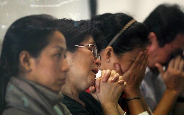 Relatives and next-of-kin of passengers on the AirAsia flight QZ8501 wait for the latest news on the search of the missing jetliner at Juanda International Airport in Surabaya, East Java, Indonesia, Monday, Dec. 29, 2014. (AP Photo/Trisnadi Marjan)
