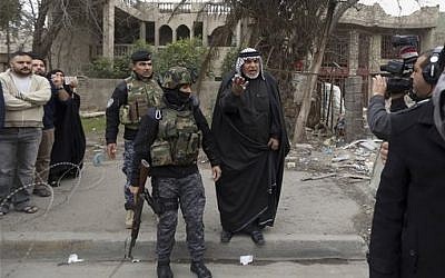 In this photo taken Tuesday, Dec. 16, 2014, a man expresses his anger at Haider Ali Motar, not seen, as they perform a scene from "In the Grip of the Law," a reality show produced by Iraqi state TV, in Baghdad, Iraq. (AP Photo/Hadi Mizban)