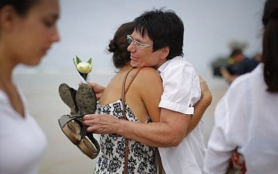 Relatives of victims of the Asian tsunami, comfort each other during a commemoration and religious ceremony for German, Austrian and Swiss victims, in Khao Lak, Thailand, Friday, Dec. 26, 2014. (Photo credit: AP/Wong Maye-E)