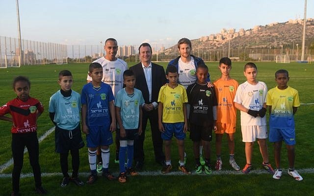 British Ambassador to Israel Matthew Gould (center, back) is pictured with Maccabi Tel Aviv soccer players Maharan Radi (left) and Sheran Yeini (right) and Jewish and Arab children from the north of Israel. (photo courtesy: Ben Kelmar/British Consulate)