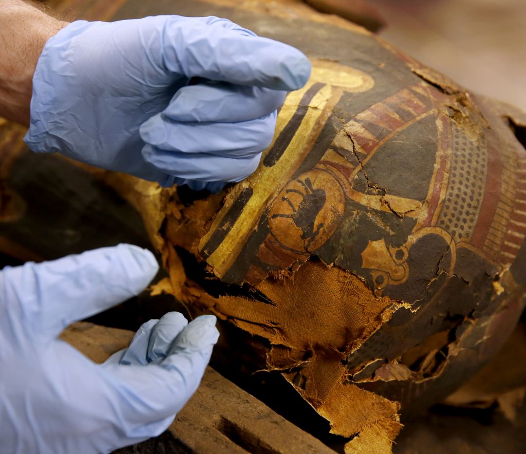 In this photo taken Friday, Dec. 5, 2014, in Chicago, P.J. Brown, Regenstein Conservator at the Field Museum examines the burial mask on the mummified body of Minirdis, a 14-year-old Egyptian boy who was the son of a priest. (photo credit: AP/Charles Rex Arbogast) In this photo taken Friday, Dec. 5, 2014, in Chicago, P.J. Brown, Regenstein Conservator at the Field Museum examines the burial mask on the mummified body of Minirdis, a 14-year-old Egyptian boy who was the son of a priest. (photo credit: AP/Charles Rex Arbogast)