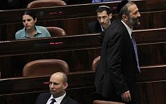 Shas head Aryeh Deri walks by head of the Jewish Home party Naftali Bennett during a plenum session in the Knesset on March 18, 2013. (Photo credit:  Miriam Alster/Flash90)