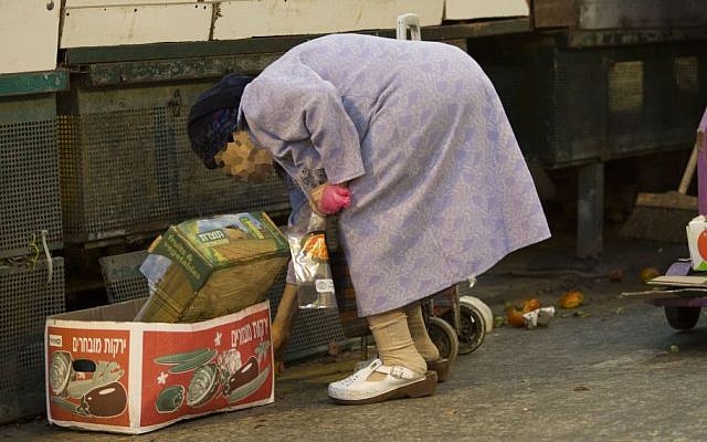 Illustrative photo of an old lady picking up vegetables off the ground in the Mahane Yehuda Market in Jerusalem as it closes for Shabbat, September 19, 2014. (Photo credit: Noam Revkin Fenton/Flash90)