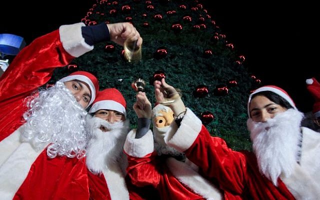 Palestinians decorate a Christmas tree in the West Bank city of Ramallah, as preparations for Christmas celebrations continue, December 7, 2014. (Photo credit: STR/Flash90) Palestinians decorate a Christmas tree in the West Bank city of Ramallah, as preparations for Christmas celebrations continue, December 7, 2014. (Photo credit: STR/Flash90)
