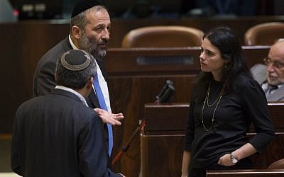 Shas party Aryeh Deri speaks with Jewish Home MK Ayelet Shaked during a vote on a bill to dissolve the Knesset, on December 8, 2014. (Photo credit: Yonatan Sindel/Flash90)