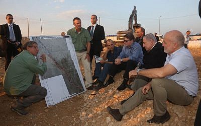 Prime Minister Benjamin Netanyahu visits the site of a large oil spill in the Arava valley in southern Israel, Tuesday, December 9, 2014 (photo credit: Marc Israel Sellem/POOL)