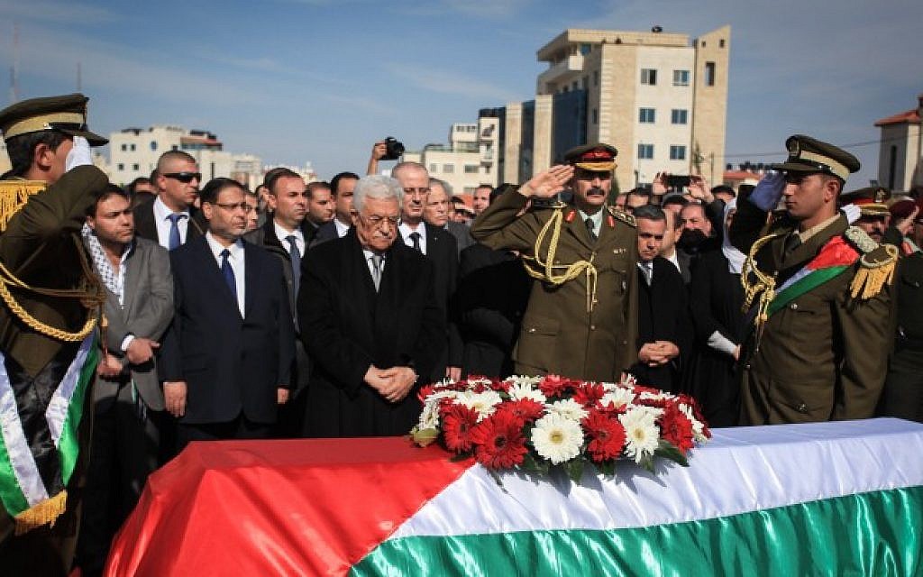 Palestinian Authority President Mahmoud Abbas stands by the coffin of senior Palestinian official Ziad Abu Ein during his funeral in the West Bank city of Ramallah, on December 11, 2014. (photo credit: STR/Flash90)