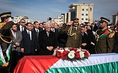 Palestinian Authority President Mahmoud Abbas stands by the coffin of senior Palestinian official Ziad Abu Ein during his funeral in the West Bank city of Ramallah, on December 11, 2014. (photo credit: STR/Flash90)