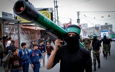 A masked Hamas member carries a model of a rocket during a rally in the Nuseirat refugee camp in the central Gaza Strip on December 12, 2014. (Abed Rahim Khatib/Flash90)