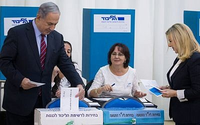 Benjamin Netanyahu casts his vote, together with his wife Sara Netanyahu, in the Likud primary elections on December 31, 2014. (Miriam Alster/Flash90)