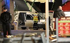 A police officer guards the van that crashed into a French Christmas market in Nantes, western France, Monday, Dec. 22, 2014. (Photo credit: AP/Laetitia Notarianni)