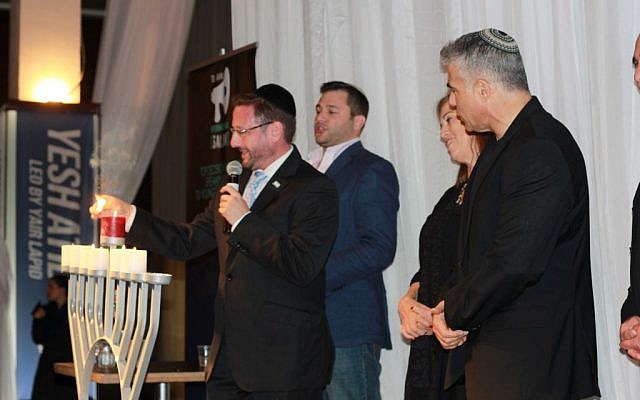 Yesh Atid MKs Dov Lipman, Ruth Calderon, and Yair Lapid light the sixth candle of Hanukkah at an event for Anglo olim on Sunday. (photo credit: Courtesy/Deborah Danan)