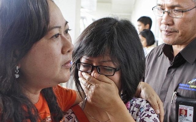 A relative of Air Asia flight QZ8501 passengers weep as she waits for the latest news on the missing jetliner at Juanda International Airport in Surabaya, East Java, Indonesia on Sunday, Dec. 28, 2014. (photo credit: AP/Trisnadi)