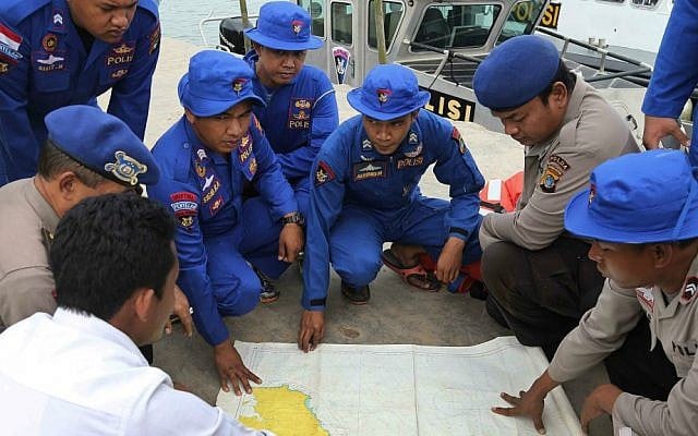 Members of Indonesia's Marine Police hold a briefing on board a search and rescue craft prior to their heading out to sea to search for the missing AirAsia flight QZ8501, at Pangkal Pinang port in Sumatra Island, Monday Dec. 29, 2014 in Indonesia. (AP Photo/Tatan Syuflana)
