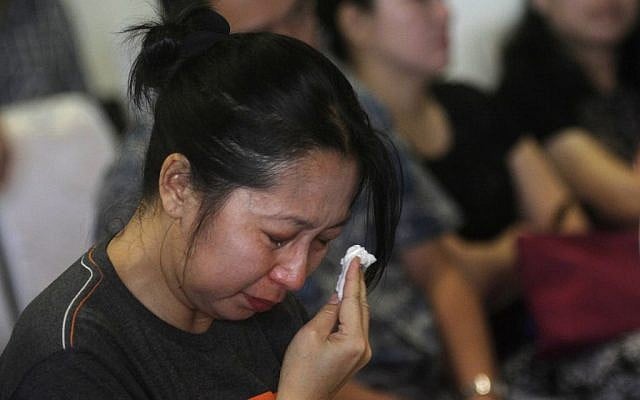 A relative of a passenger on the AirAsia flight QZ8501 wipes tears as she awaits the latest news on the search of the missing jetliner at Juanda International Airport in Surabaya, East Java, Indonesia, Monday, Dec. 29, 2014. (photo credit: AP Photo/Trisnadi Marjan) A relative of a passenger on the AirAsia flight QZ8501 wipes tears as she awaits the latest news on the search of the missing jetliner at Juanda International Airport in Surabaya, East Java, Indonesia, Monday, Dec. 29, 2014. (photo credit: AP Photo/Trisnadi Marjan)