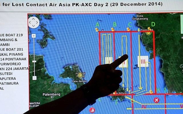 A member of the Indonesian National Search and Rescue Agency (BASARNAS) points to a map of a search area during a briefing prior to a search and rescue operation of the missing AirAsia flight QZ8501, at Pangkal Pinang command post in Sumatra Island, Monday, Dec. 29, 2014 in Indonesia. (AP Photo/Tatan Syuflana)