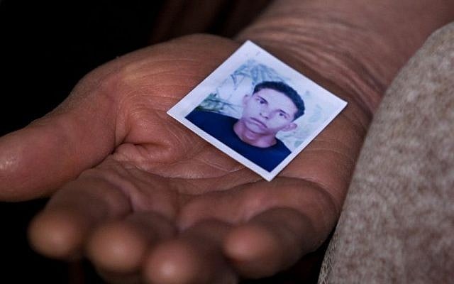 The mother of Mohamed Bouazizi, the local fruit vendor who set himself on fire December 17, 2010, holds a picture of him, in the town of Sidi Bouzid, Tunisia, March 8, 2011. (AP/Giorgos Moutafis, File)