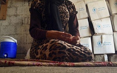Illustrative: A 15-year-old Yazidi girl captured by the Islamic State group and forcibly married to a militant in Syria sits on the floor of a one-room house she now shares with her family after escaping, October 8, 2014. (AP/Dalton Bennett, File)