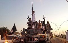 Fighters from the Islamic State group parade in a commandeered Iraqi security forces armored vehicle down a main road at the northern city of Mosul, June 23, 2014. (photo credit: AP/File)